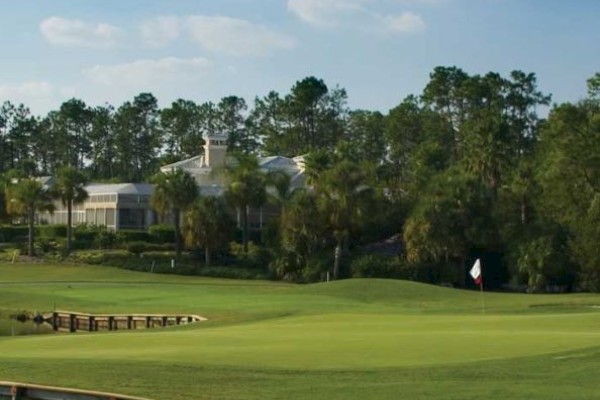 It's a serene golf course with a green fairway, trees, and buildings