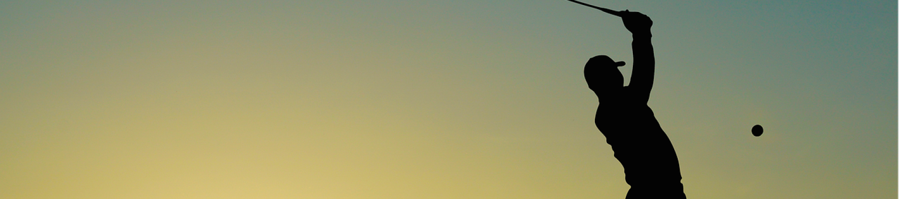 A silhouette of a golfer in mid-swing at sunset, with a flagstick in the background. The sun is low on the horizon, casting a warm glow.