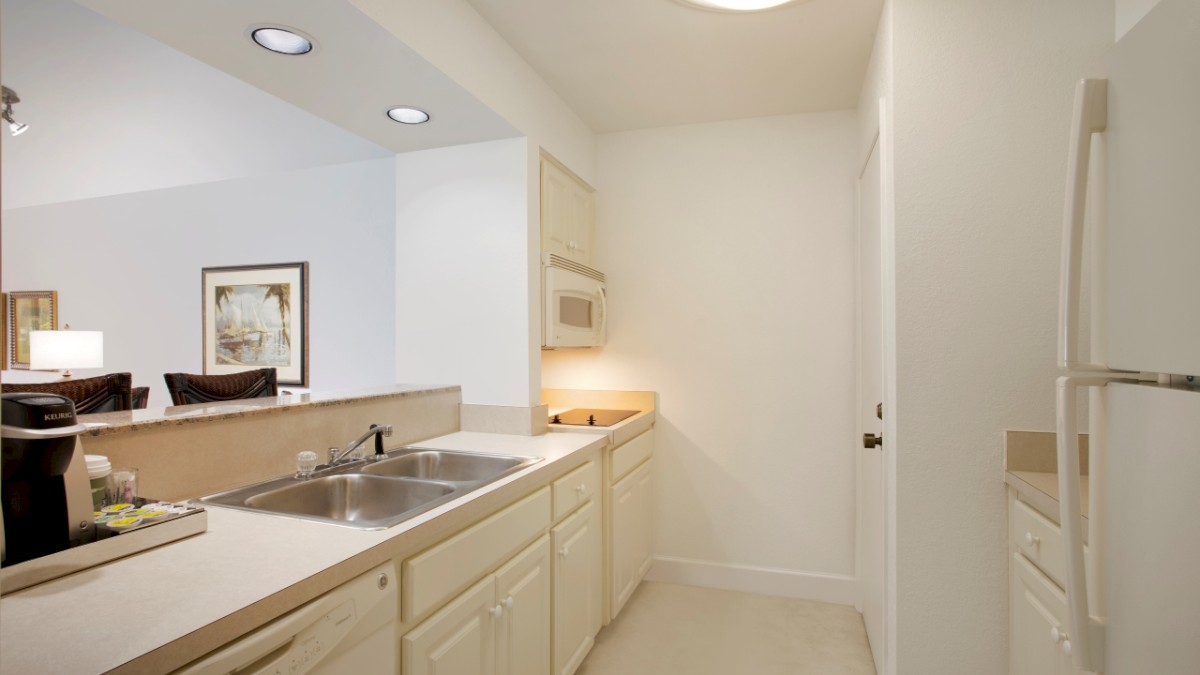 A small, well-lit kitchen with white cabinets and appliances.