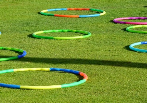 The image shows brightly colored hula hoops spread out on a grass field, creating a playful and vibrant scene perfect for outdoor activities.